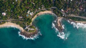Stunning aerial view of Thangalla Beach, Sri Lanka, showcasing turquoise waters and lush greenery.